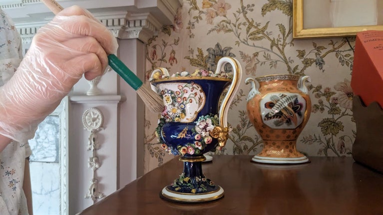 A House Team member cleaning a vase at Dunster Castle in Somerset